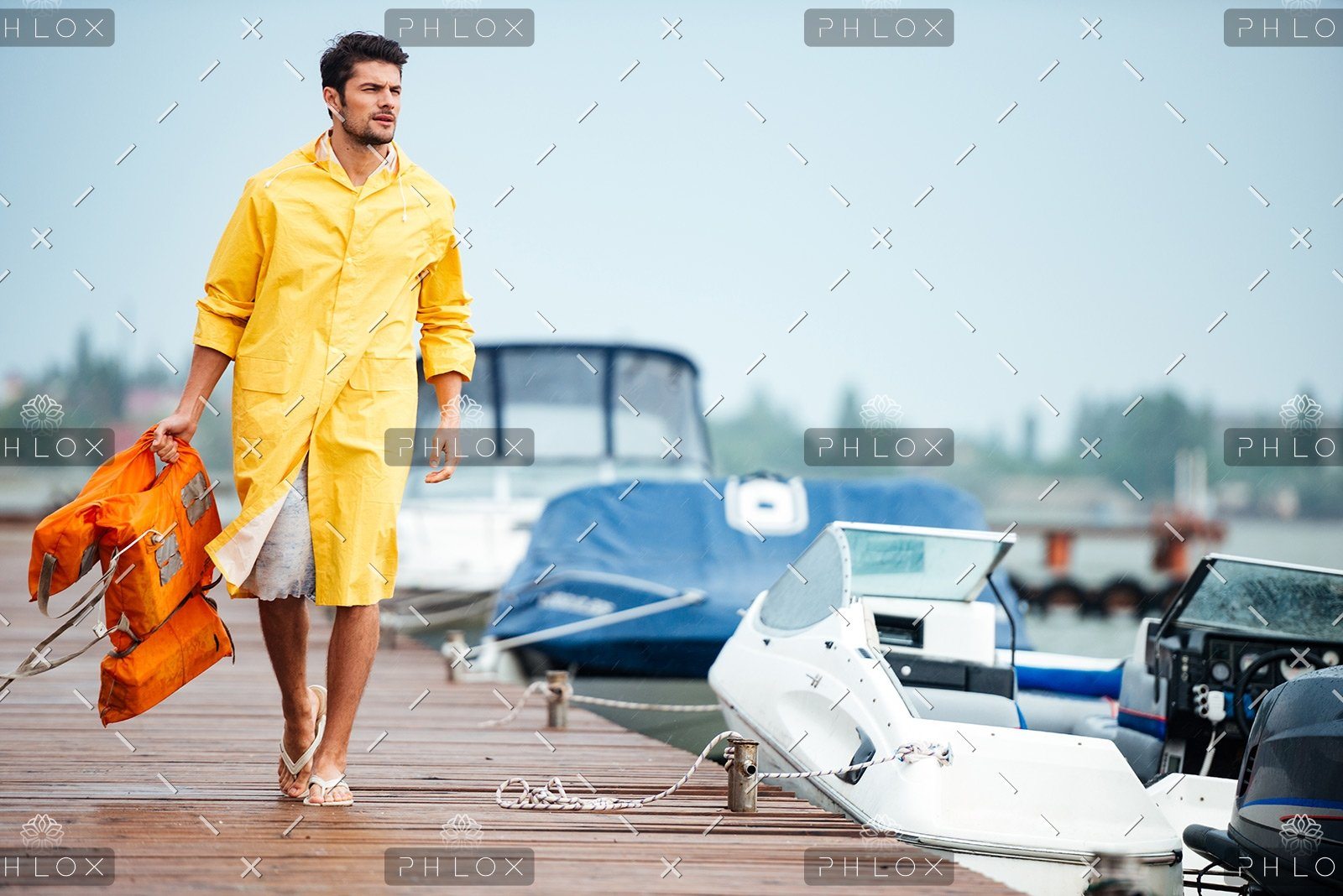 demo-attachment-32-sailor-in-yellow-cloak-at-the-pier-holding-life-PX7M94D